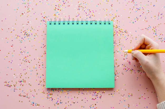 Caderno em branco e caneta com confete