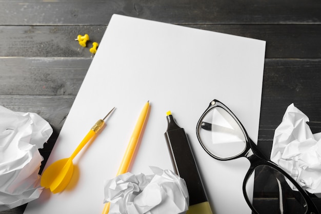 Caderno em branco e lápis com óculos na mesa de madeira