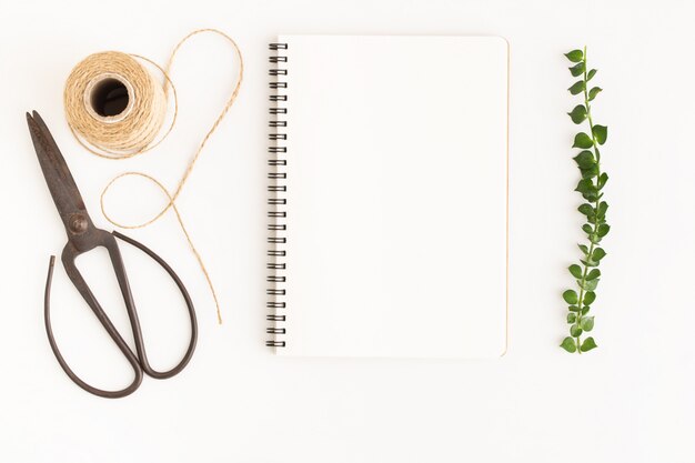 Caderno em branco e tesoura em fundo branco