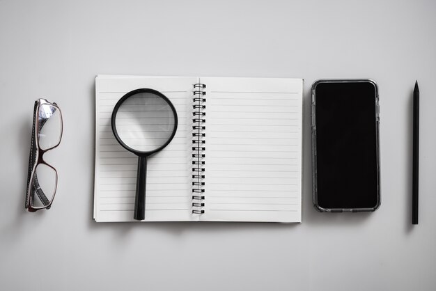 Caderno em branco está no topo da mesa de escritório branco.