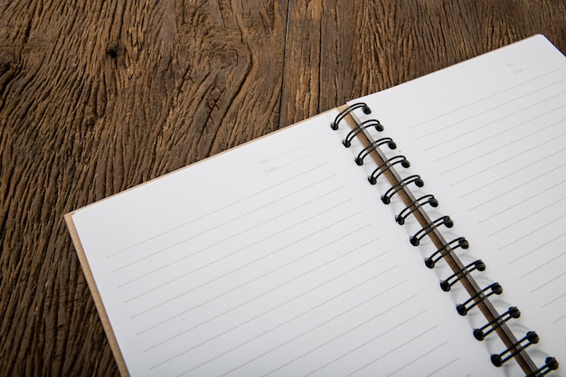 Caderno em branco na mesa de madeira de trabalho