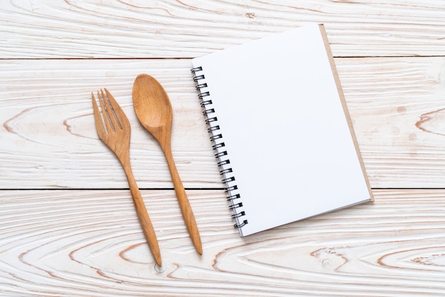 Caderno em branco para nota de texto na superfície de madeira