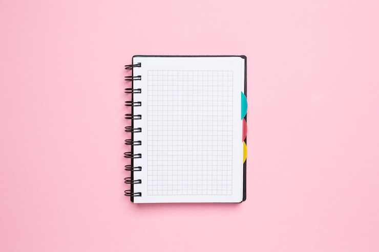 Foto caderno em uma gaiola em um fundo rosa