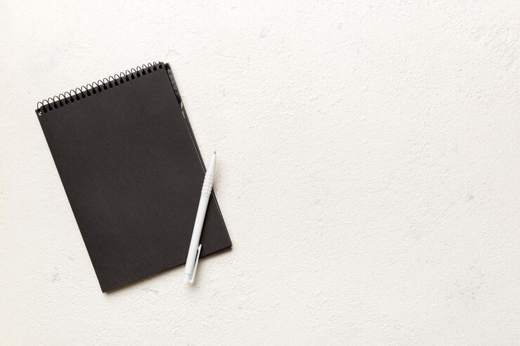 Foto caderno escolar em um bloco de notas preto espiral de fundo colorido em uma mesa vista superior