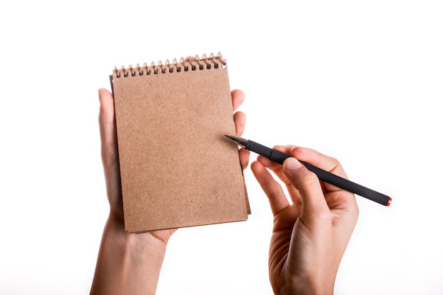 Caderno espiral com caneta na mão da criança