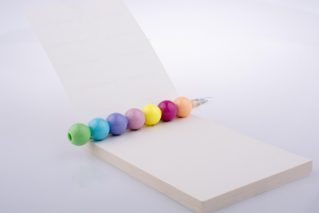 Caderno espiral e miçangas coloridas em um fundo branco