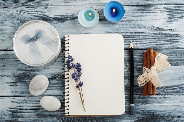 Caderno, flores de lavanda, velas, seixo