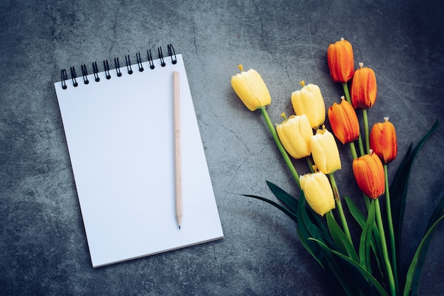 Caderno, lápis e flor em preto