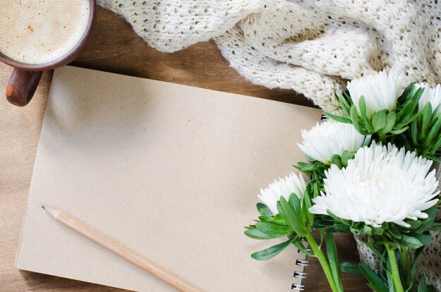 Caderno marrom em branco com flores de outono.