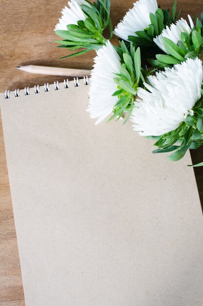 Caderno marrom em branco com flores de outono.