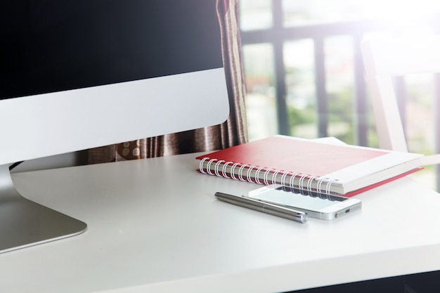 Foto caderno na mesa com o computador no escritório em casa