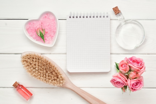 Foto caderno quadriculado e escova de madeira com cosméticos e perfume