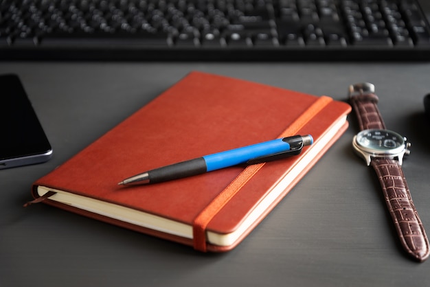 Foto caderno vermelho de brown em um fundo escuro.