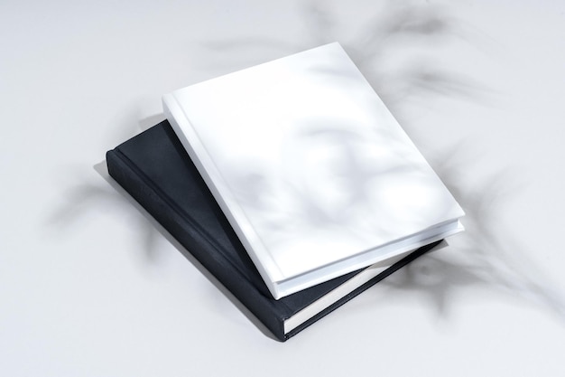 Cadernos de capa dura pretos e brancos em fundo cinzento