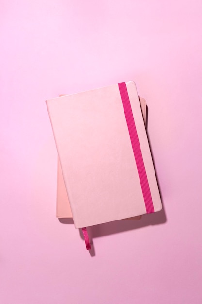 Cadernos de vista superior na área de trabalho rosa