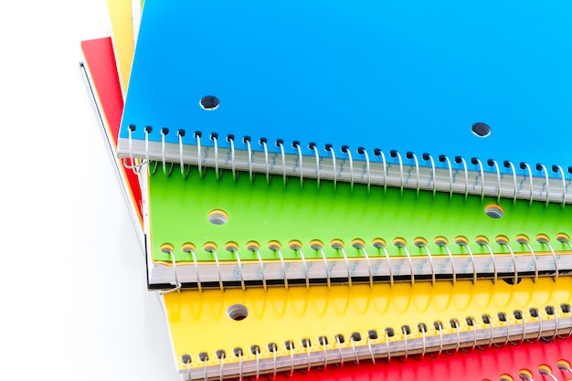 Cadernos espirais multicoloridos em um fundo branco.