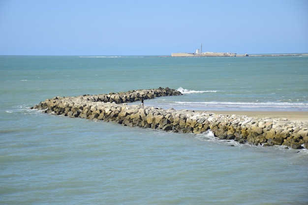 Cádiz España 06 de noviembre de 2019 Un hombre en rompeolas de hormigón cerca de la playa de la ciudad