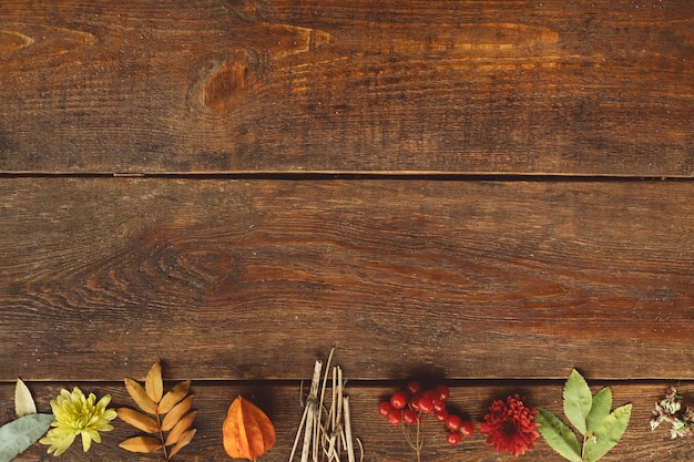 Caen las hojas de otoño en la pared de madera rústica