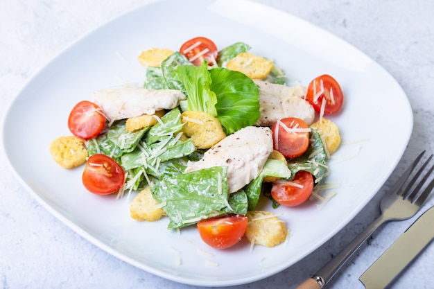 Caesar (Cesar) Salat mit Hühnchen, Crackern, Parmesan und Kirschtomaten. Nahansicht.