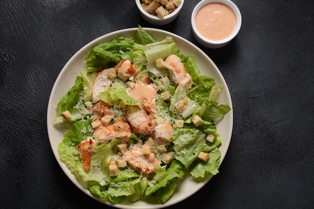 Caesar Salad mit gegrilltem Hühnchen, Käse und Croutons mit Salat, auf Teller. Gegrillte Hähnchenbrust und frisches Gemüse in der Platte.