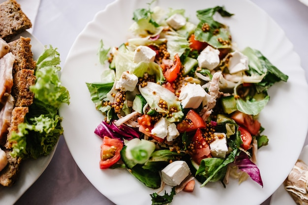 Caesar salat in einem weißen teller am hintergrund des tisches. nahansicht