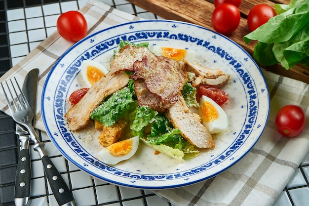 Caesar Salat mit Croutons, Parmesan, Huhn, Ei in einer weißen stilvollen Schüssel. Restaurant servieren. Selektiver Fokus, Holztisch