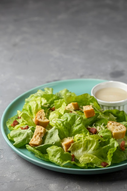 Caesar-Salat mit Croutons und Speck.