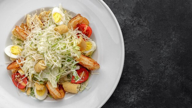 Caesar Salat mit Garnelen auf dunklem Hintergrund