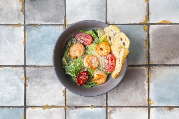 Caesar-Salat mit Garnelen und Parmesankäse auf Fliesenhintergrund hochwertiges Foto