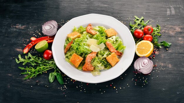 Caesar-Salat mit Hähnchen und frischem Gemüse Auf einem hölzernen Hintergrund Ansicht von oben Kopieren Sie Platz