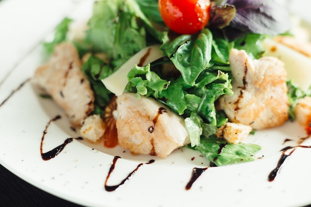 Caesar-Salat mit Huhn auf weißem Teller