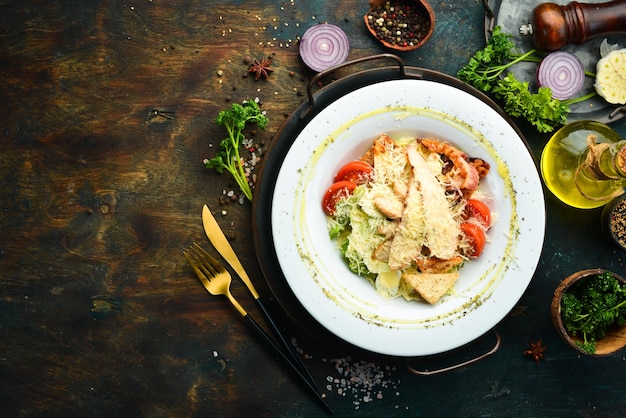 Caesar-Salat mit Huhn und Speck Draufsicht auf dunklem Hintergrund