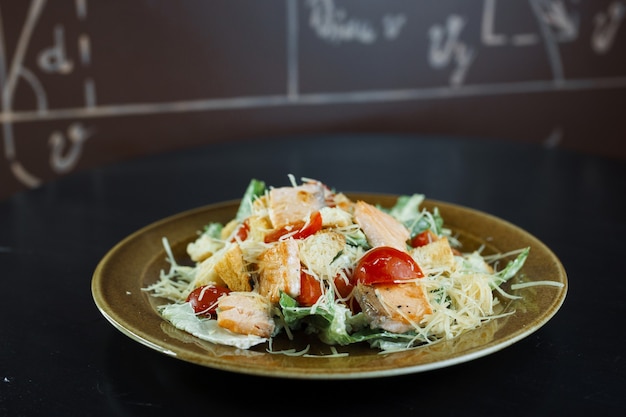 Caesar-Salat mit Salat, Kirschtomaten und Hartkäse mit Scheiben aromatisiertem Hähnchenfilet mit Weißbrotcroutons und einer köstlichen leichten Sauce. Wunderbar leckeres Abendessen.