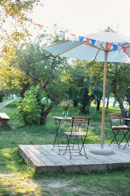 Café al aire libre interior de la calle con sombrilla, mesas y sillas