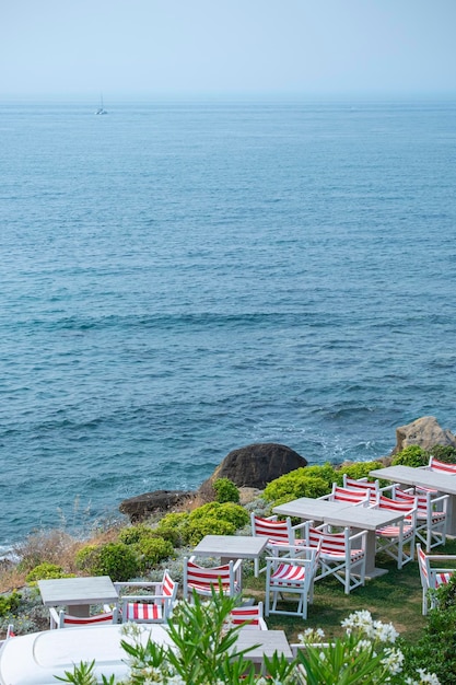 Café am Wasser am Meer mit Tischen im Freien und Panoramablick