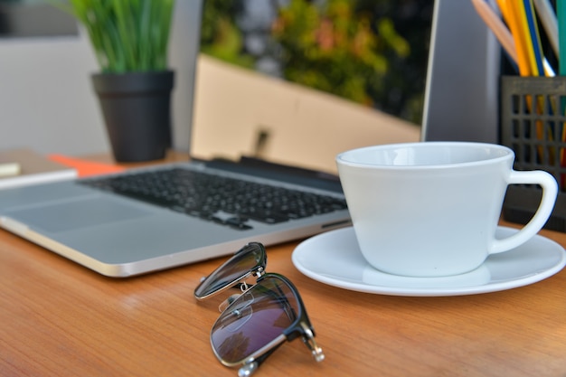 Café Americano Caliente, en una taza de café con leche En la mesa de trabajo