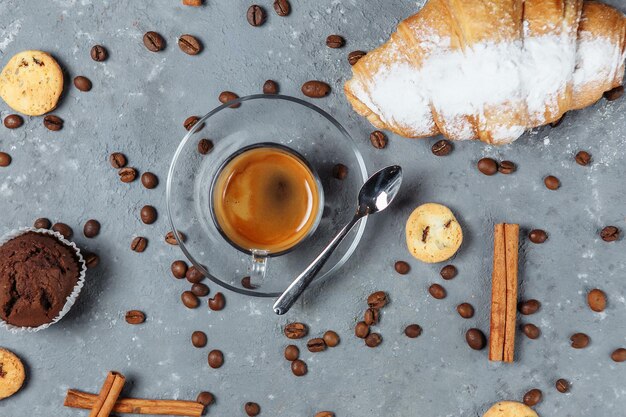 Café Americano sobre un fondo con croissant de granos y canela