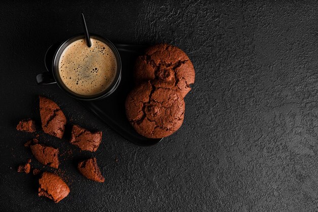 Café americano en taza sobre fondo oscuro. Café caliente con espuma. Café con galleta de chocolate. foto de alta calidad