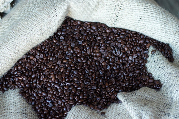 Café árabe oscuro tostado en grano Granos de café en una bolsa de primer plano Fondo con espacio de copia