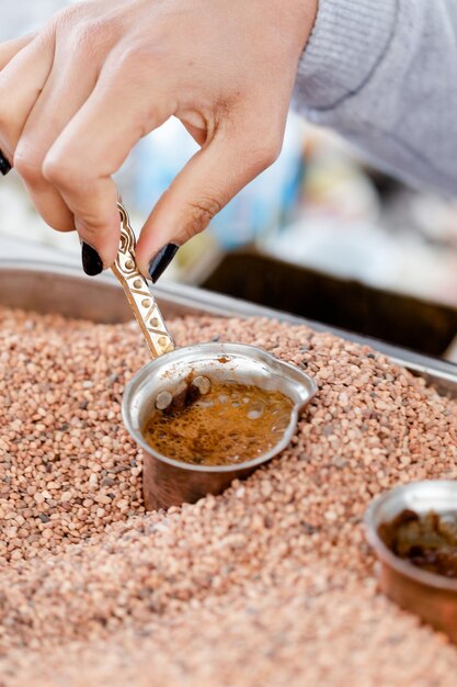 Foto café árabe turco tradicional fabricado em pequenos copos de cobre em areia quente em close-up