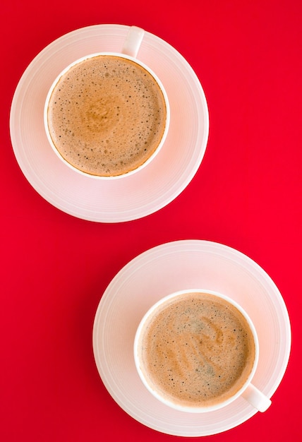 Café aromático caliente sobre fondo rojo flatlay