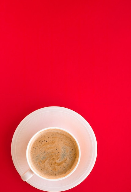 Café aromático caliente sobre fondo rojo flatlay
