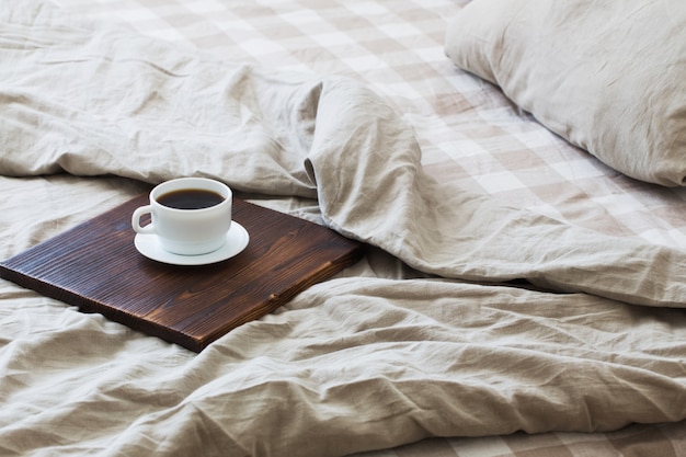 Foto café en bandeja en la cama en dormitorio