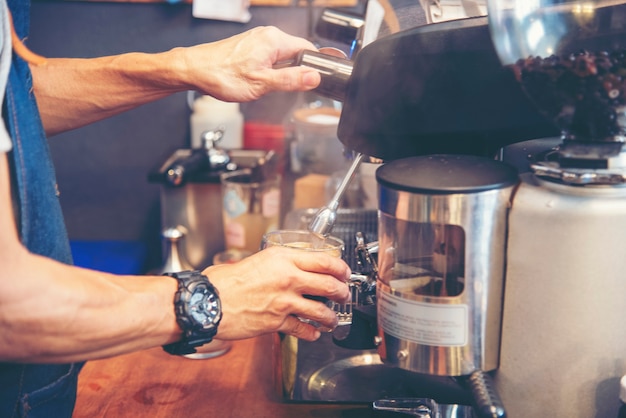 Café barista faz café expresso da xícara quente da cafeteira