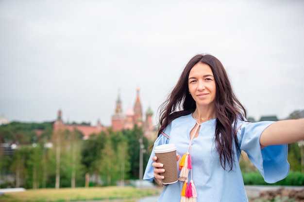 Café bebendo da mulher urbana nova feliz na cidade europeia.