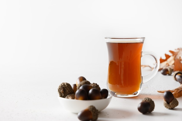 Café de bellota con hojas de roble en el cuadro blanco. De cerca. Espacio para texto.