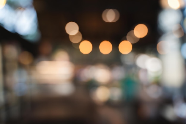 Café borroso con fondo bokeh Imagen borrosa de un espacio interior acogedor con luces colgantes cálidas que crean una atmósfera suave y acogedora
