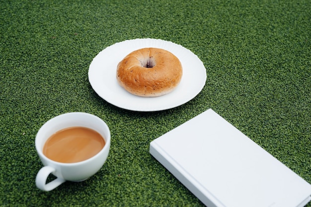 Café, un buen libro y pan para un buen día en cafetería.