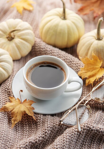 Café de calabazas blancas y hojas de otoño.