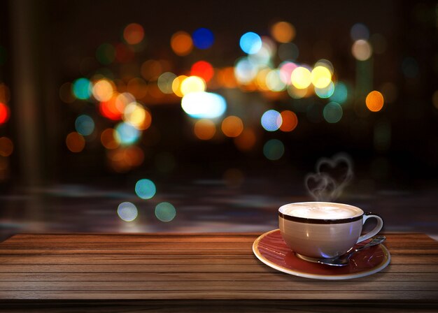 Café caliente con el corazón del humo y el fondo del bokeh.